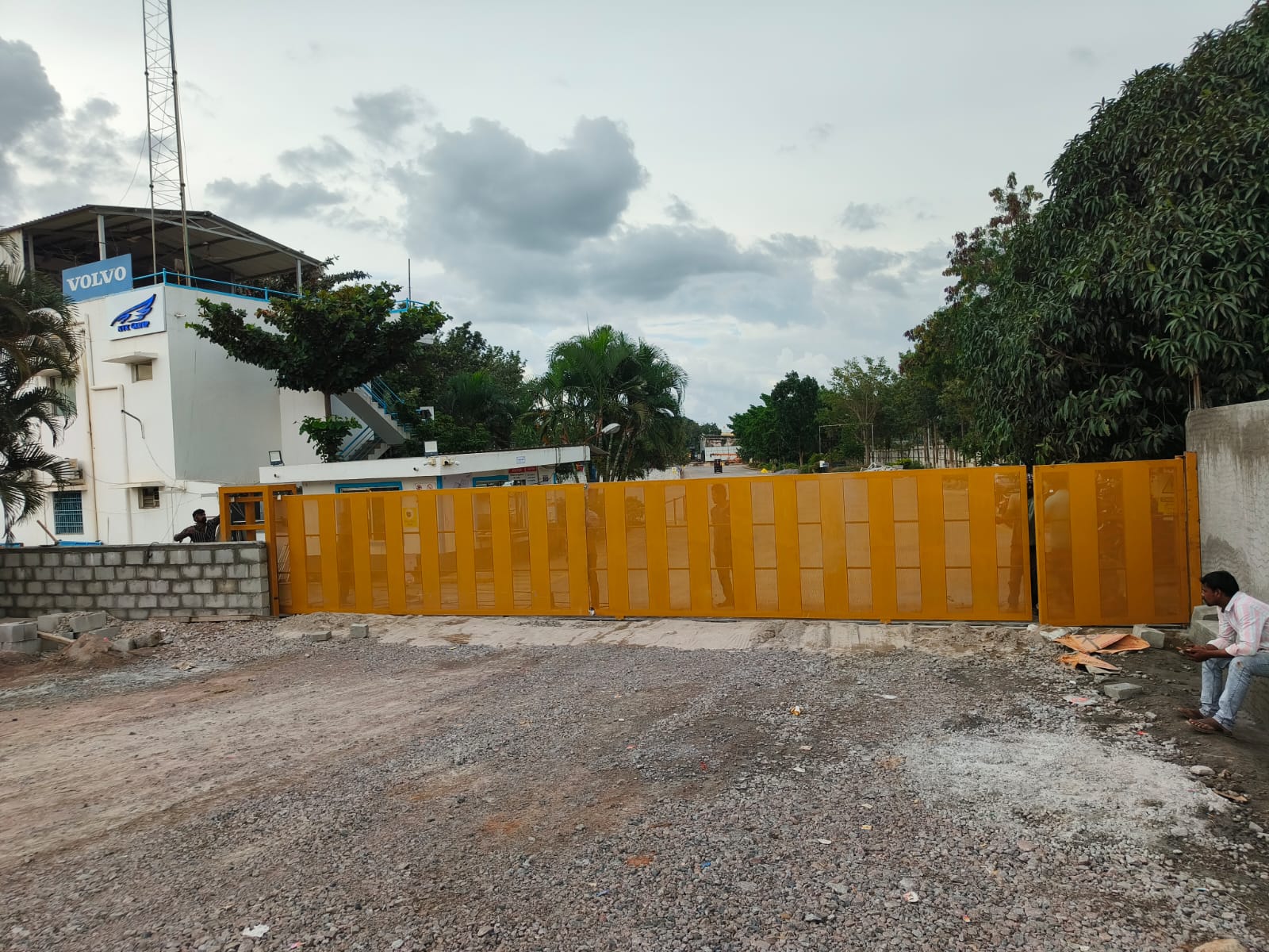 Orange industrial sliding gate at a commercial entrance