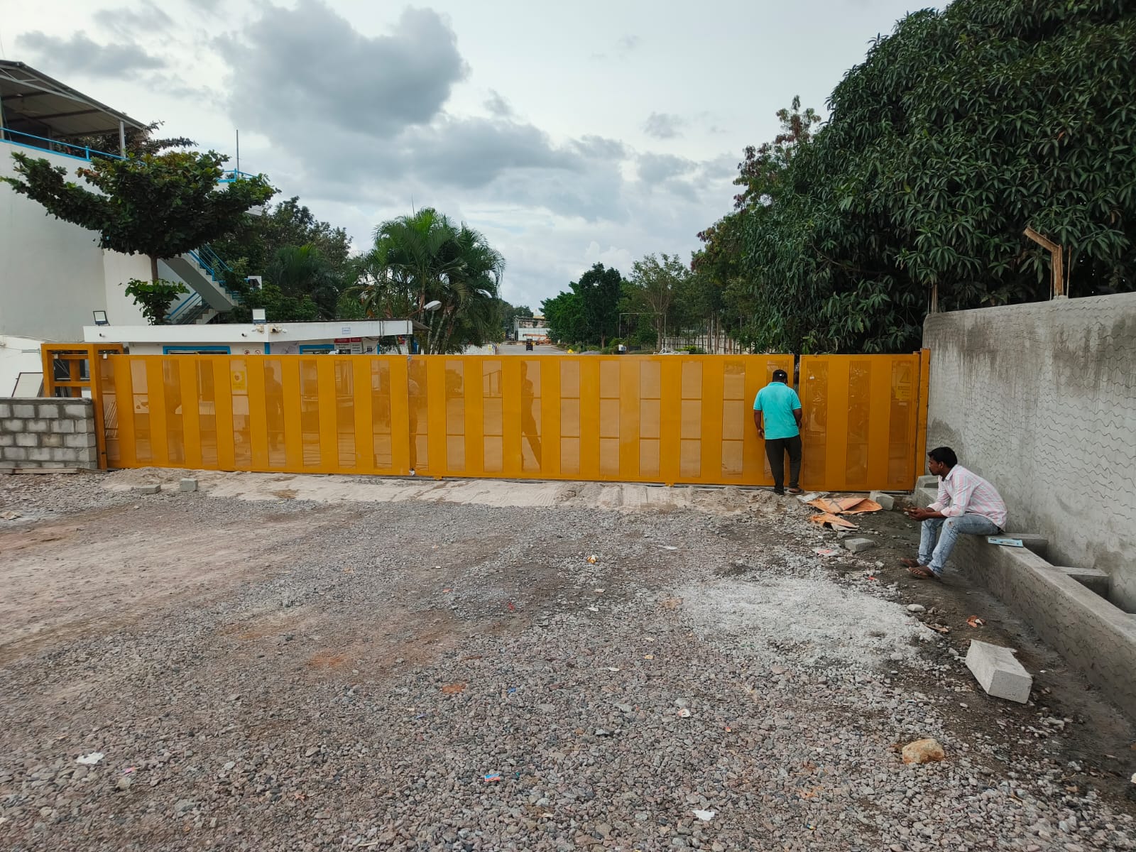 Wide orange sliding gate at a company entrance