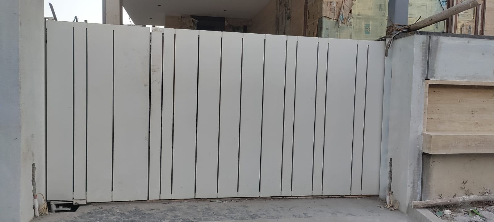 White metal sliding gate at a residential entrance